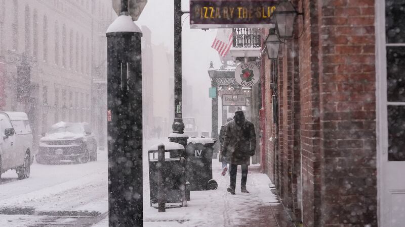 A man walks down Bourbon Street during a very rare snowstorm in New Orleans, Tuesday, Jan. 21,...