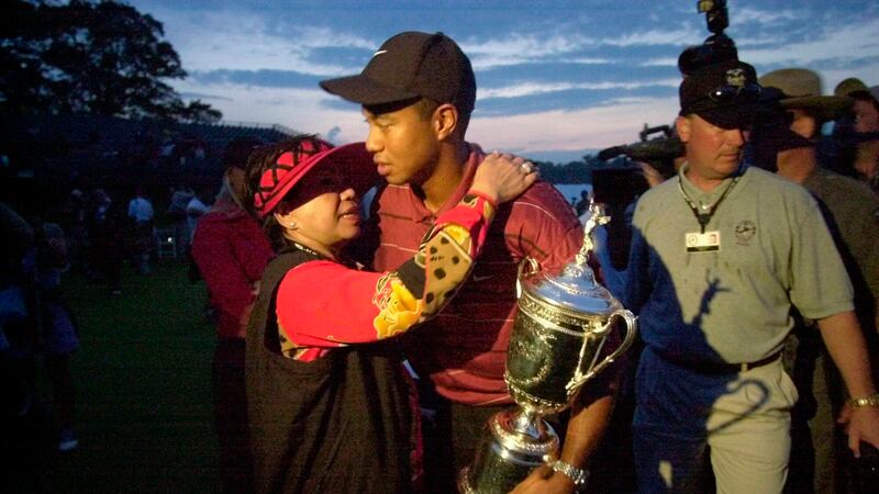 FILE - In this Sunday, June 16, 2002, file photo, Tiger Woods holds his trophy and embraces...