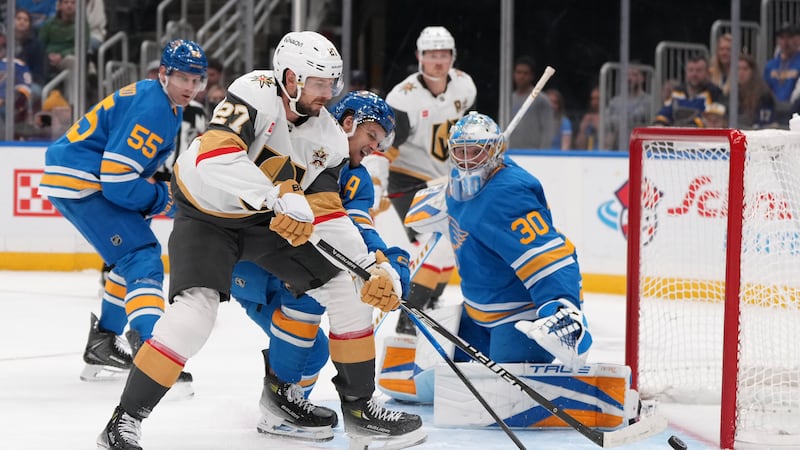 Vegas Golden Knights' Shea Theodore (27) reaches for a loose puck as St. Louis Blues...