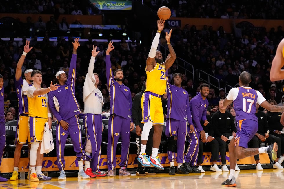 Los Angeles Lakers forward LeBron James, center, shoots as his teammates gesture from the...