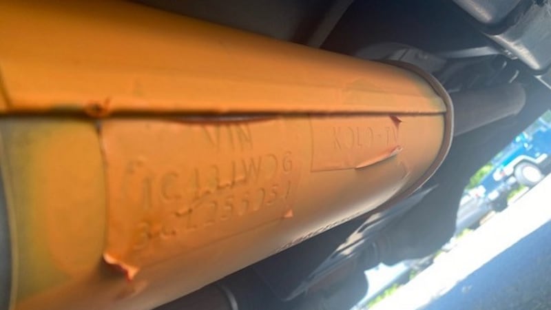 Catalytic converter with sticker and spray paint helps stop thieves from taking it.