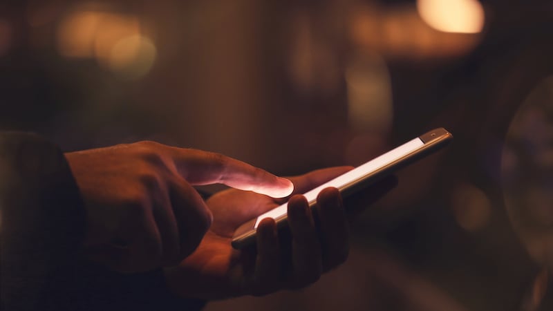 Man using mobile phone at night on street