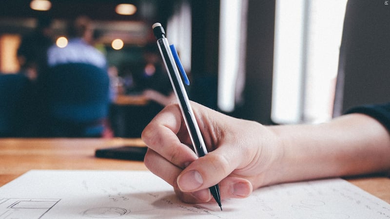 School student writing on paper generic