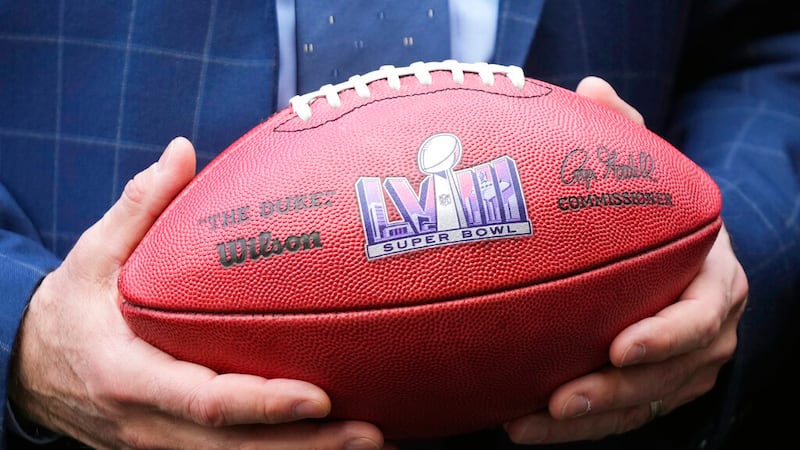 Nevada Republican Gov. Joe Lombardo holds an NFL football with the Super Bowl LVIII logo on it...