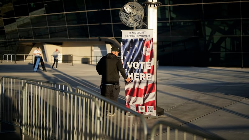 FILE - A poll worker adjusts a sign outside the Allegiant Stadium polling place, Tuesday, Nov....