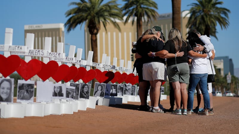 In this Oct. 1, 2019, file photo, people pray at a makeshift memorial for shooting victims in...
