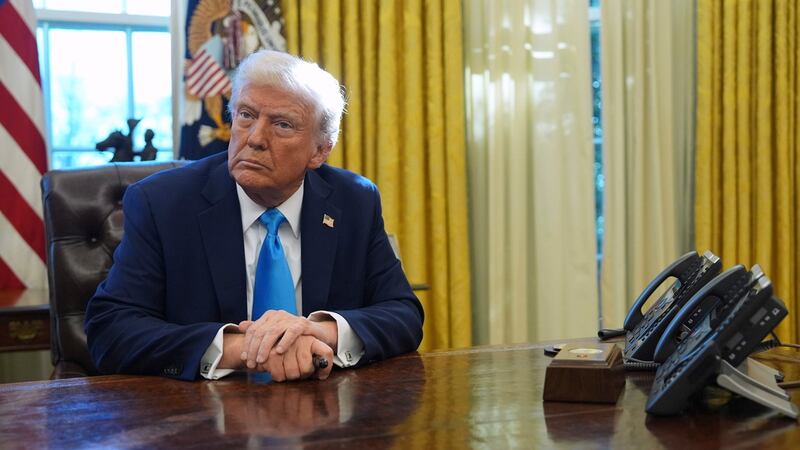 El presidente Donald Trump escucha preguntas de la prensa en el Despacho Oval de la Casa...