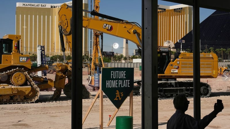 A person takes a picture near construction equipment during a groundbreaking ceremony for the...