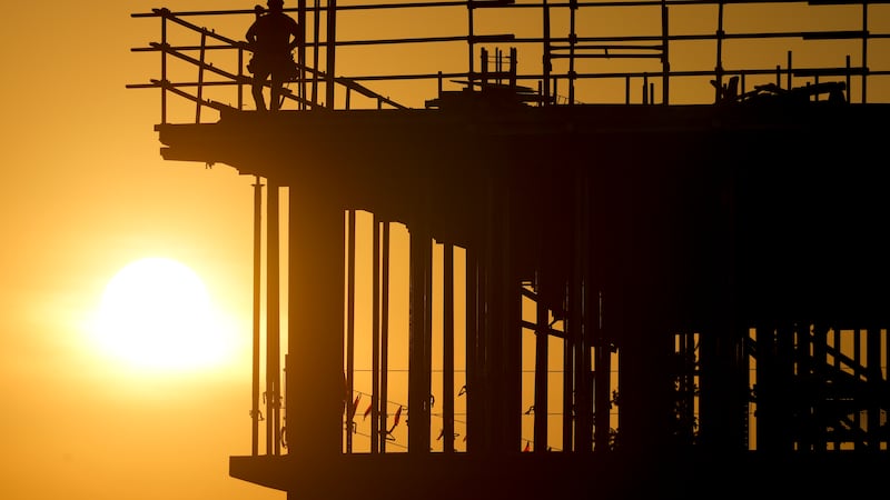 Construction workers start their day as the sun rises on the new Republic Airlines...