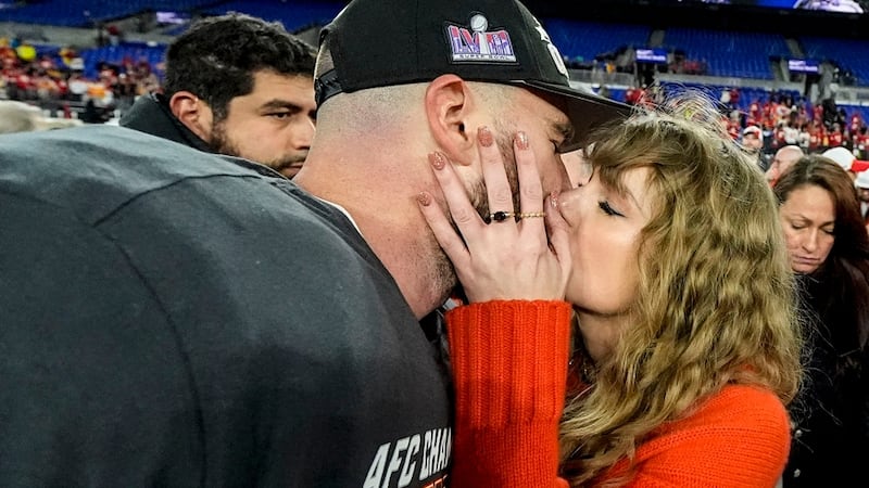 Taylor Swift kisses Kansas City Chiefs tight end Travis Kelce after an AFC Championship NFL...