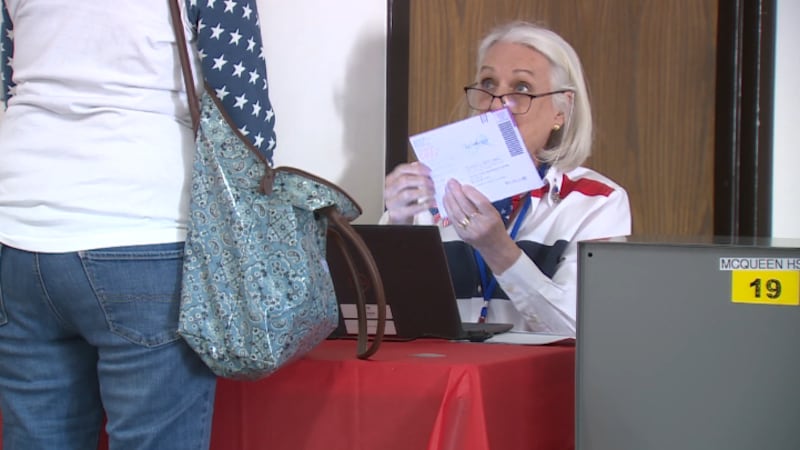 Election worker helping voter with mail in ballot taken to voting site