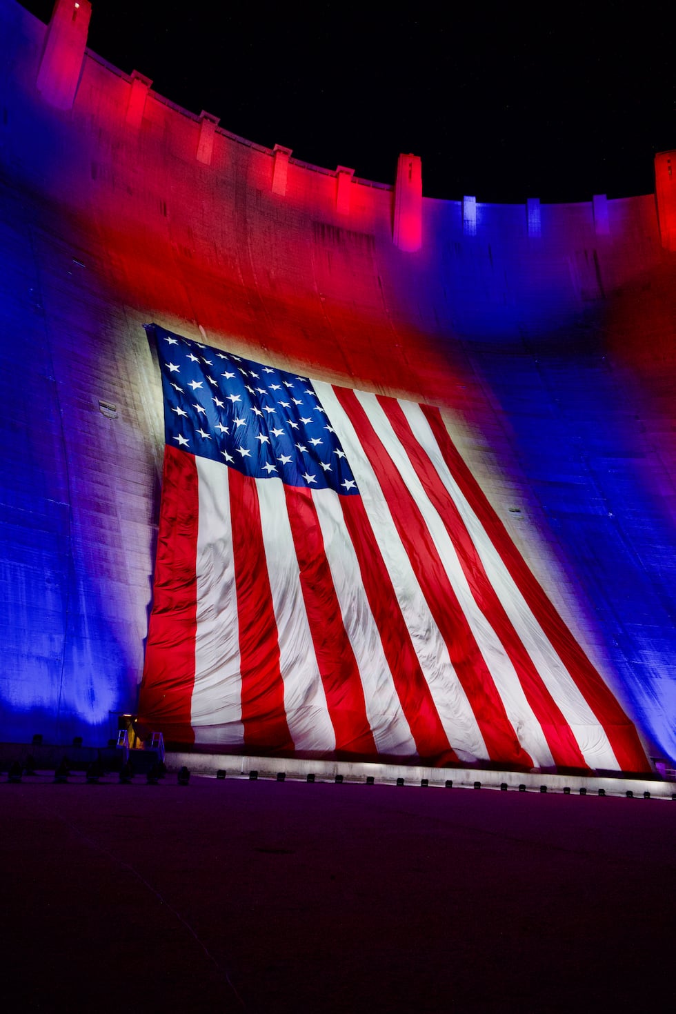 An American Flag is displayed on the face of the Hoover Dam.