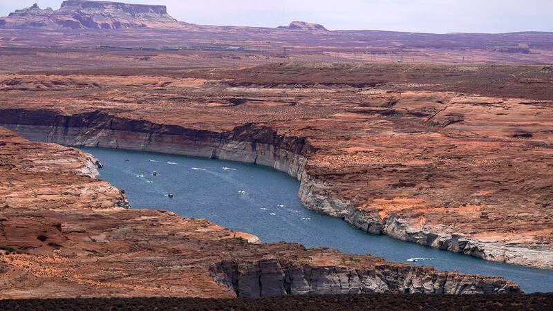 Boats move along Lake Powell along the Upper Colorado River Basin Wednesday, June 9, 2021, in...