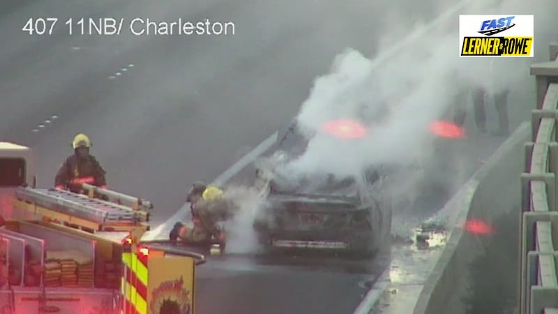 Firefighters extinguish a car fire seen on I-11 near Charleston on Thursday morning, Jan. 22,...