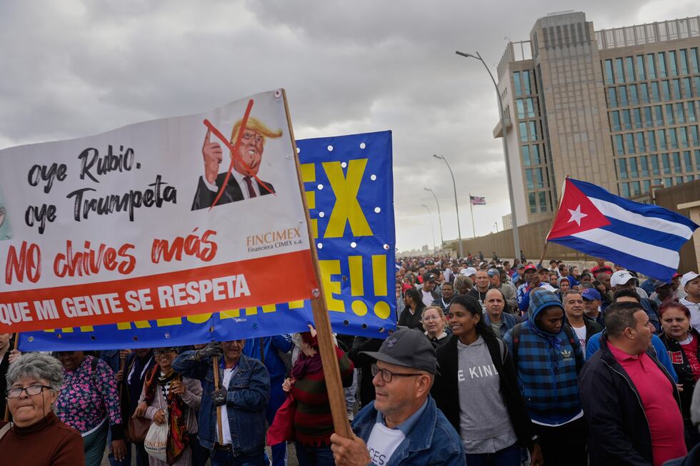 People holding a banner against President Donald Trump, march outside the U.S. Embassy to...