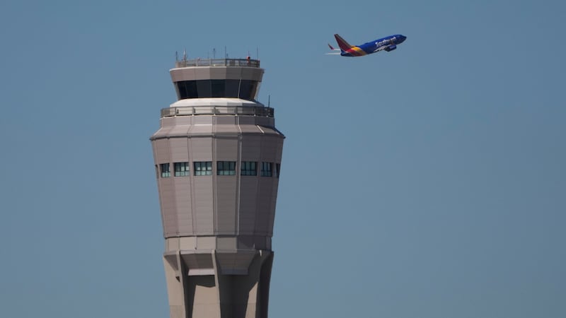 A plane takes off near the air traffic control tower at Harry Reid International Airport,...