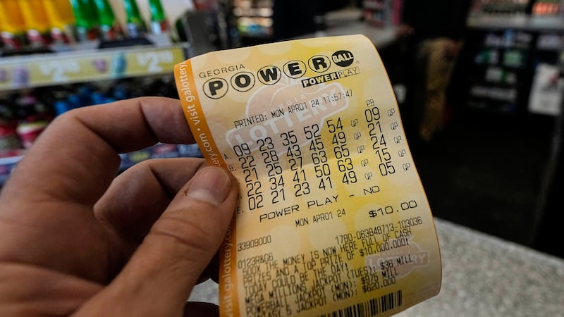 FILE - A Powerball lottery ticket is seen inside a convenience store, Monday, April 1, 2024,...
