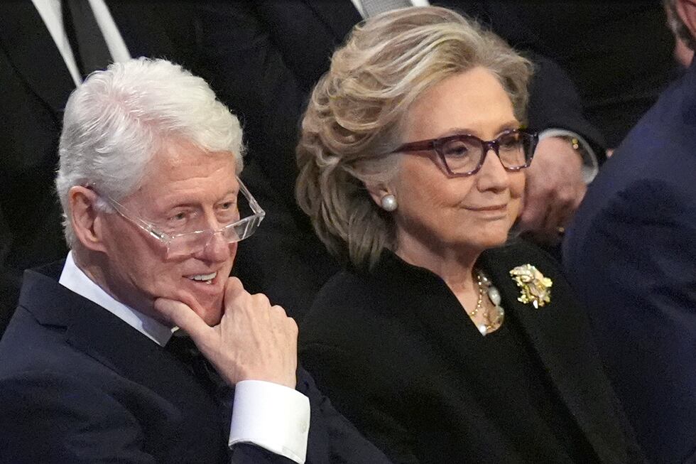 FILE - Former President Bill Clinton and former Secretary of State Hillary Clinton listen...